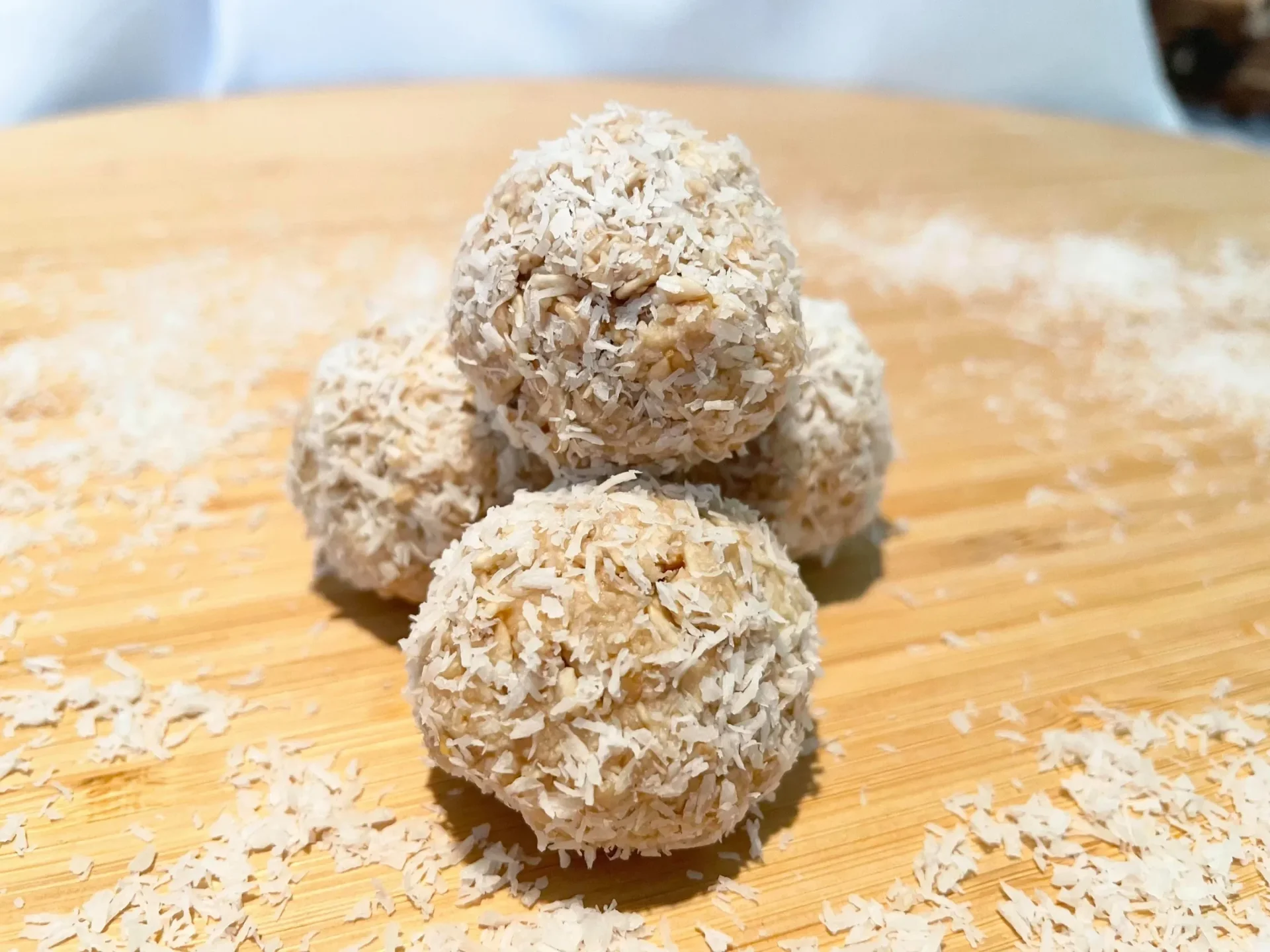 Coconut-rolled natural dog treat bliss balls on a wooden board
