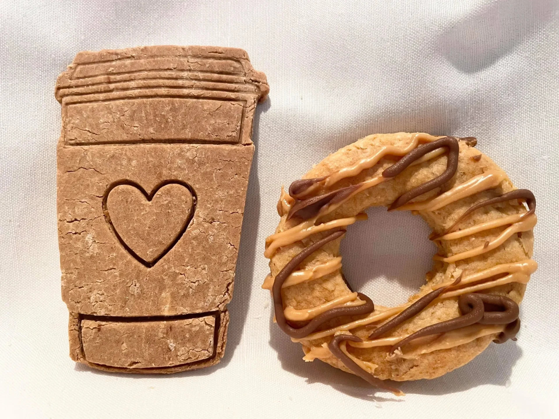 Cafe-style dog treats — coffee cup shaped biscuit with heart and a drizzled donut treat